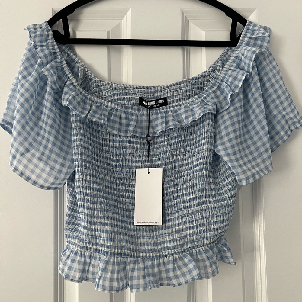 New off the shoulder cropped frilly top. Stretch in the breast area.